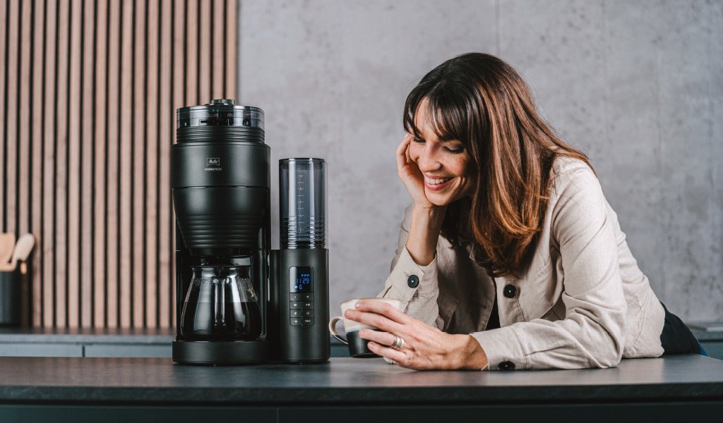 Frau trinkt Kaffee neben einer Melitta AromaFresh