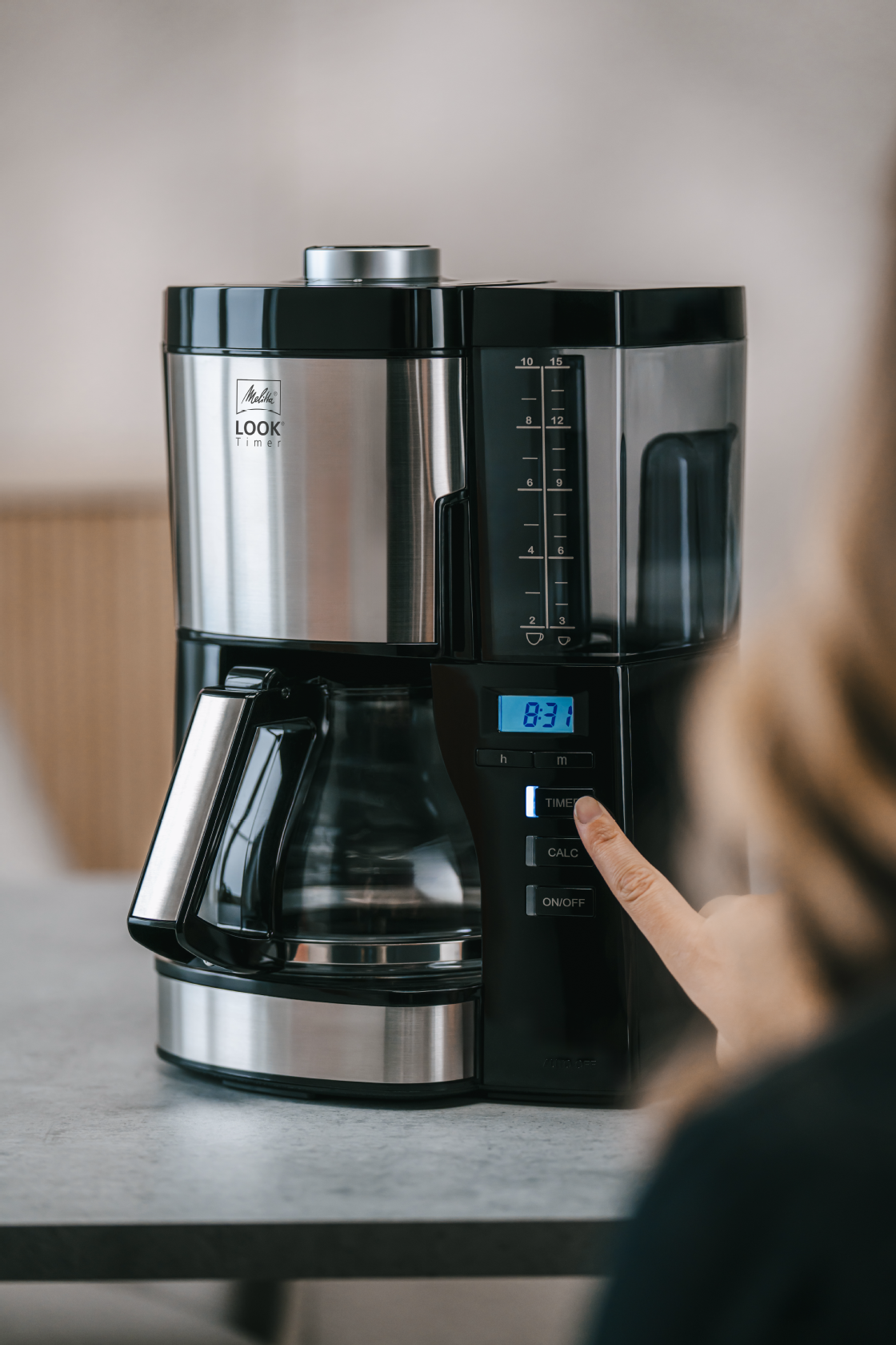 Person stellt den Timer der Melitta® LOOK® Timer Filterkaffeemaschine ein