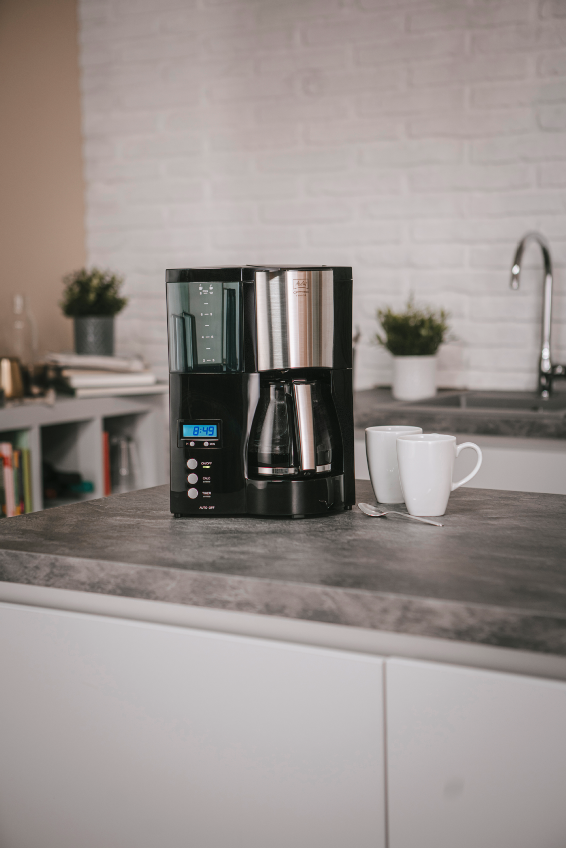 Melitta Optima® Timer Filterkaffeemaschine mit Glaskanne auf einer Küchenarbeitsplatte.
