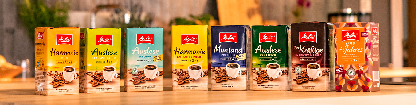 Melitta gemahlene Kaffeesorten in einer Reihe auf einer hölzernen Küchentheke