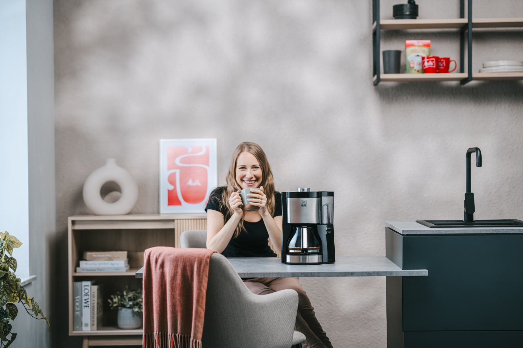 Frau genießt Kaffee neben der Melitta® LOOK® Perfection Filterkaffeemaschine