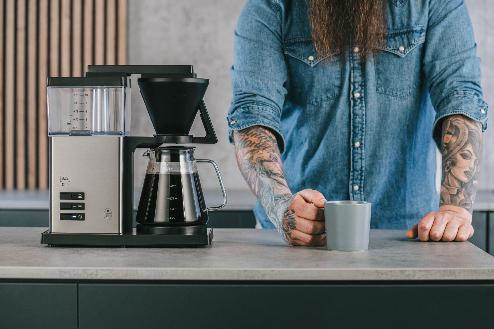 Person mit der Melitta One® Filterkaffeemaschine in der Küche