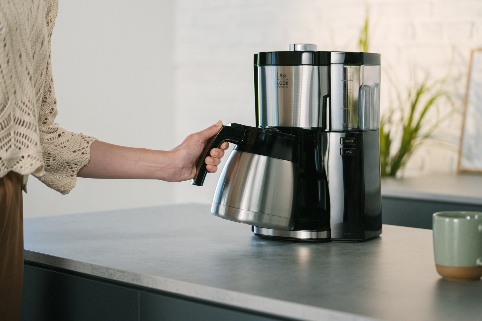 Hand hält die Thermkanne der Melitta® LOOK® Therm Perfection Filterkaffeemaschine