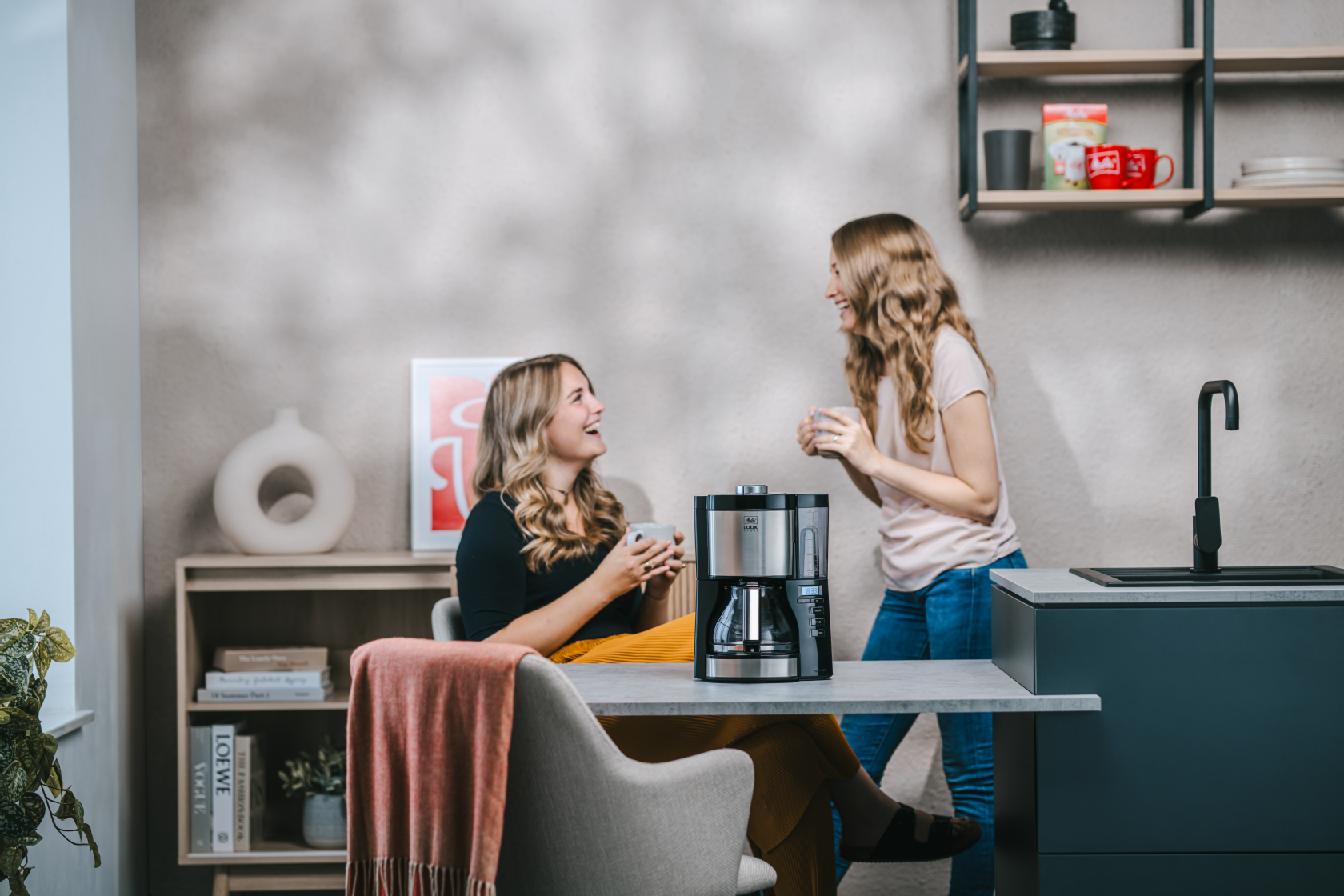 Zwei Frauen genießen Kaffee neben der Melitta® LOOK® Timer Filterkaffeemaschine
