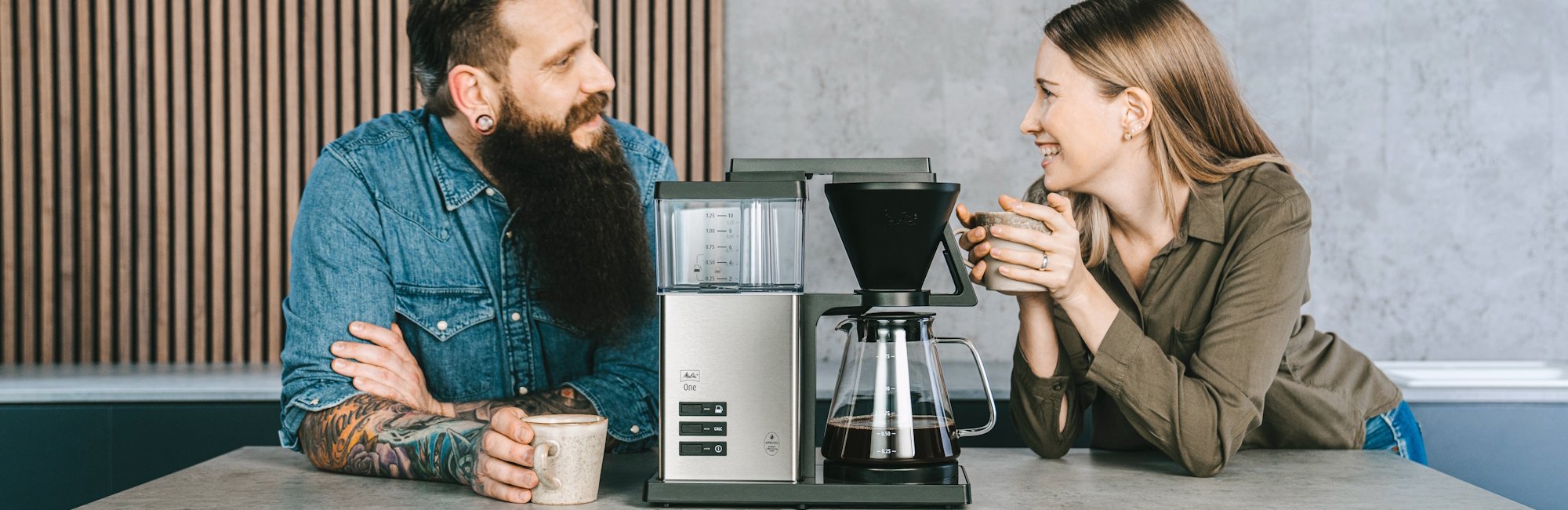 Paar genießt Kaffee neben der Melitta One® Filterkaffeemaschine