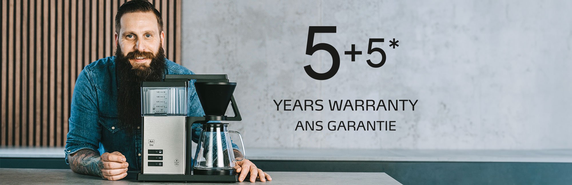 Man presenting our Melitta One coffee maker with a 10-year warranty