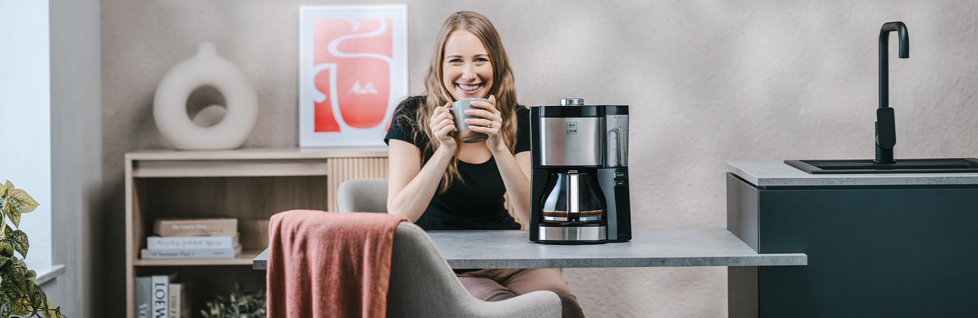 Frau genießt Kaffee neben der Melitta® LOOK® Perfection Filterkaffeemaschine