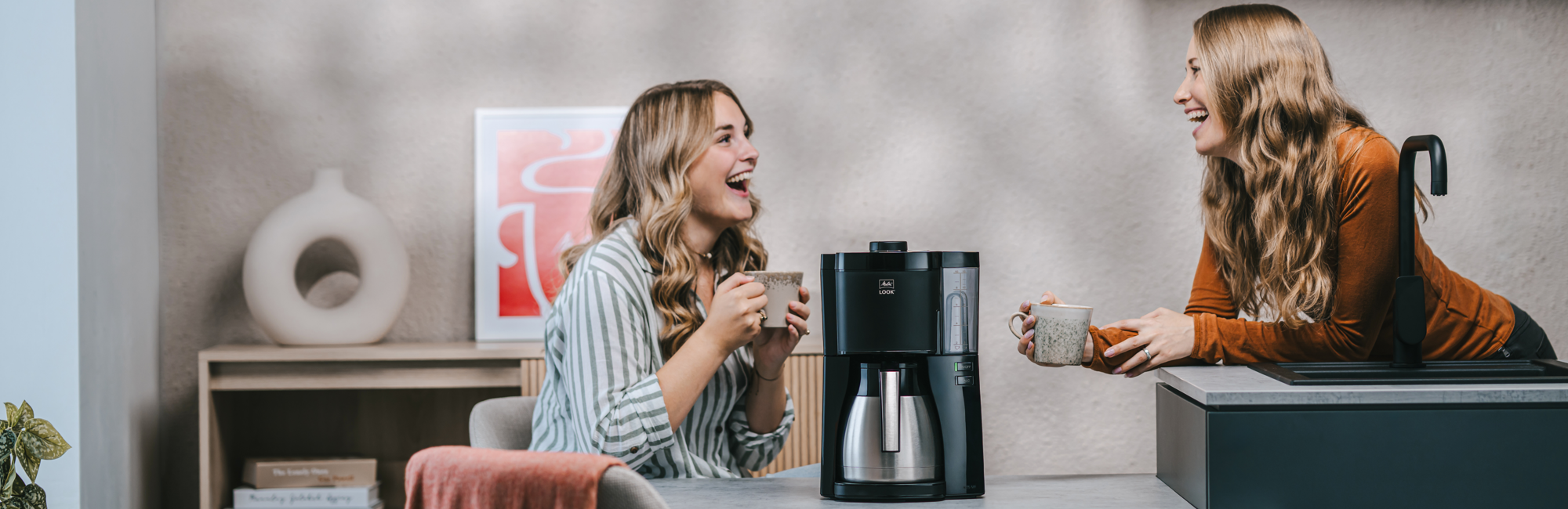 Zwei Frauen genießen Kaffee neben der Melitta® Look® Therm Filterkaffeemaschine