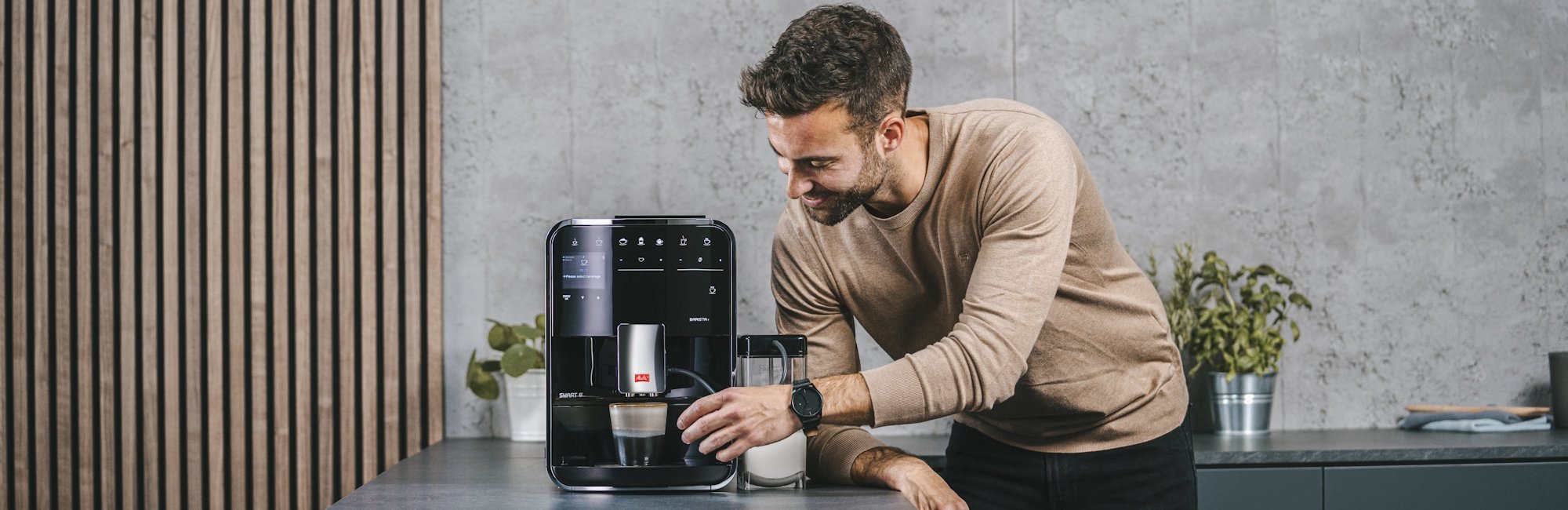 Mann bedient eine Melitta Barista T Smart mit Milchbehälter in einer modernen Küche