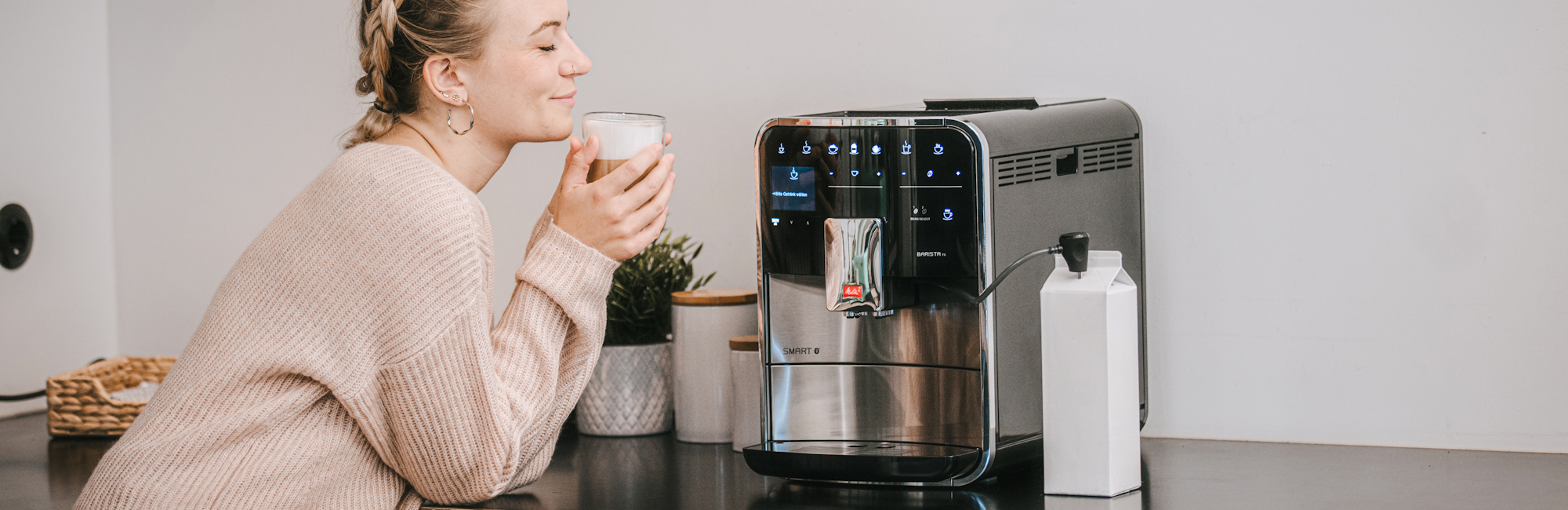 Melitta Barista TS Smart with a woman enjoying a fresh cup of coffee