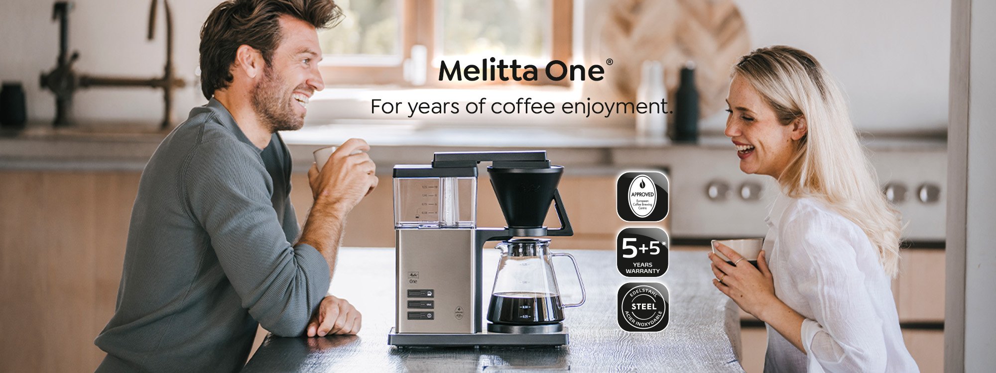 2 Personen sitzen an einem Tisch und genießen ihren Kaffee aus der Melitta One Filterkaffeemaschine