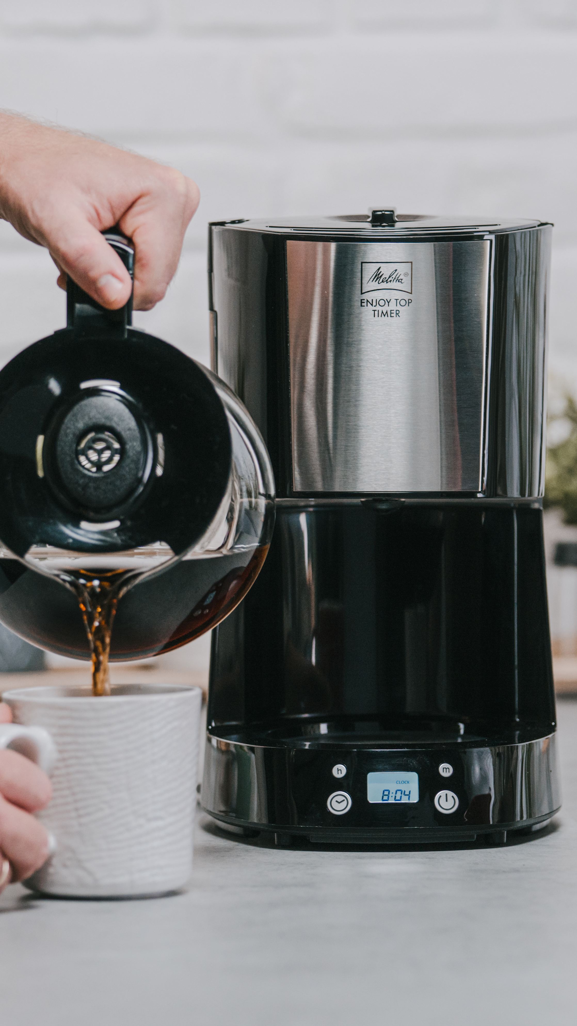 Kaffee wird aus der Melitta Enjoy Top Timer Filterkaffeemaschine mit Digitalanzeige in eine Tasse gegossen