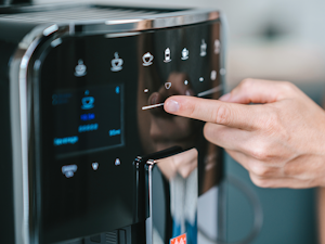 Melitta Barista T Smart mit Finger bei der Getränkeauswahl über das Touchpanel