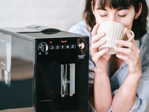 Eine Frau genießt ihren Kaffe von der Melitta Purista