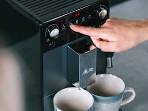 Model Macht sich einen Melitta Kaffee von einem Melitta Vollautomat
