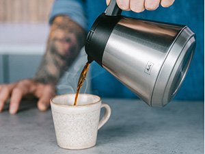 Kaffee wird aus der Isolierkanne der Melitta One® Therm Filterkaffeemaschine in eine Tasse gegossen.