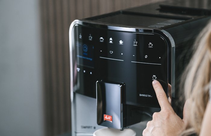 Nahaufnahme der Melitta Barista T Smart mit Finger bei der Getränkeauswahl