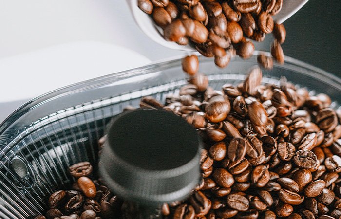 Nahaufnahme von Kaffeebohnen, die in den Bohnenbehälter der Melitta® AromaFresh X Filterkaffeemaschine eingefüllt werden